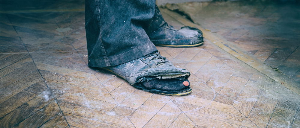 Old untidy shoes with holes in them.